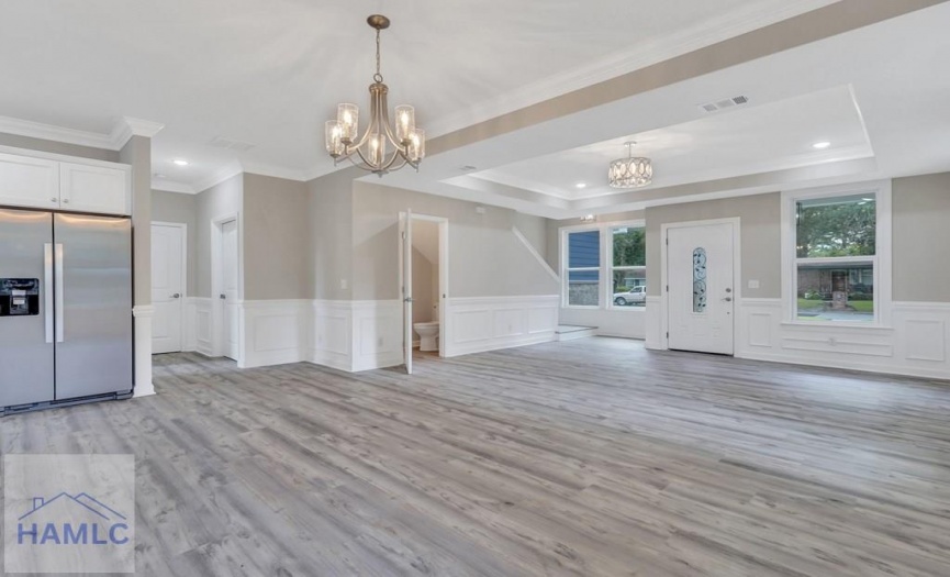 Open concept living/dining room area with crown mo