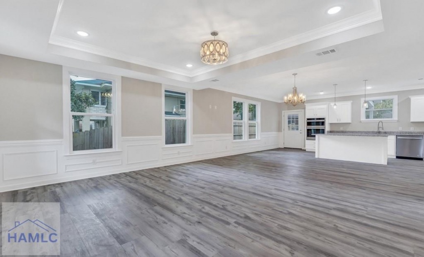 Open concept living/dining room area with crown mo